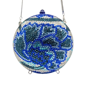 Detailed view of spherical evening clutch with blue floral crystals and silver chain