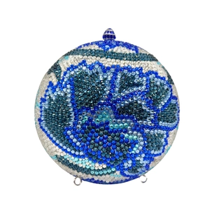 Macro detail of round evening bag with blue floral rhinestone crystal pattern