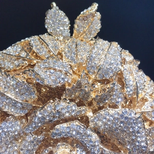 Pochette de soirée camélia dorée avec design de feuilles ajourées et strass brillants