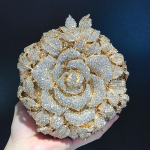Détail du fermoir en forme de feuille sur la pochette rose dorée ornée de strass brillants