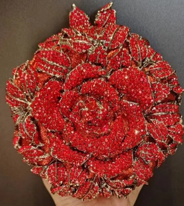 Gros plan sur une pochette de soirée rose rouge avec des pétales de cristal brillants