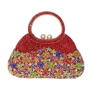 Détail d'un sac de soirée en strass rouges avec motif floral et fermoir en perle