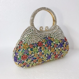 Vue détaillée des motifs floraux en cristal coloré et du fermoir perle du sac de soirée