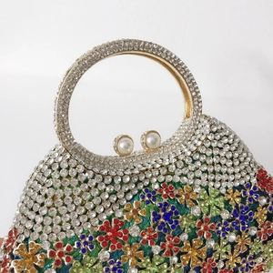 Détail du sac de soirée avec strass floraux colorés et fermoir à perles élégantes
