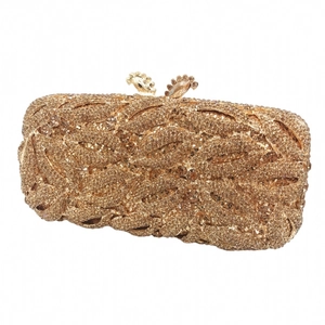 Detail of leaf-shaped rhinestone texture and floral metal clasp on golden clutch