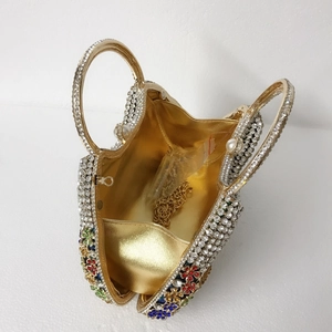 Vue intérieure d'une pochette en strass avec doublure dorée, fleurs et bandoulière