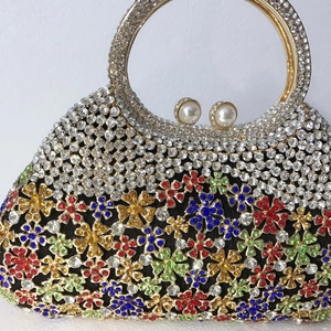 Détail de pochette de luxe avec strass floraux, poignée métal et fermoirs perles