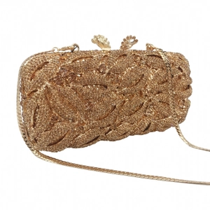 Detail of luxury gold lip clutch bag with hollow metal leaf patterns and sparkling crystals