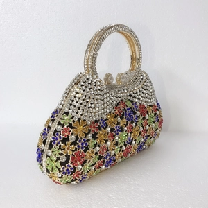 Détail d'une pochette de soirée avec motifs floraux en cristaux et fermoir en perle