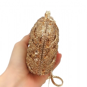 Detail of gold lip-shaped evening clutch bag with sparkling rhinestones and metal chain