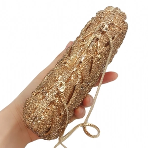 Detailed macro view of sparkling gold rhinestones and hollow metal frame on evening clutch