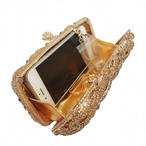 Golden lip-shaped clutch bag with rhinestones, metal hollow design, and chain strap