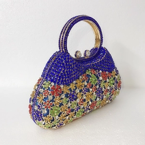 Vue détaillée des motifs floraux en strass sur une pochette de soirée bleue de luxe