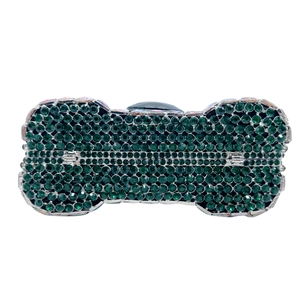 Macro detail of dark green crystal-encrusted bone-shaped evening clutch with silver trim