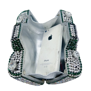 Silver rhinestone clutch showing internal capacity with green diamond accents