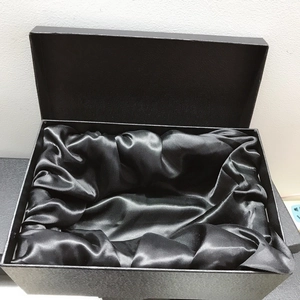 Detail of luxury black textured gift box with premium satin lining for evening clutch bag