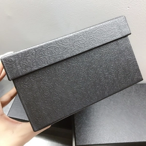 Detail view of a luxury black rectangular gift box with embossed floral texture patterns