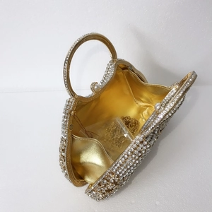 Vue intérieure de la pochette dorée en strass avec fermoir perle et bandoulière chaîne