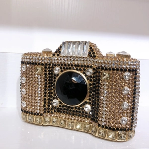 Detail view of crystal-encrusted camera evening bag with a large faceted black gemstone lens