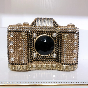 Detailed view of luxury camera-shaped clutch bag with hand-set sparkling rhinestones