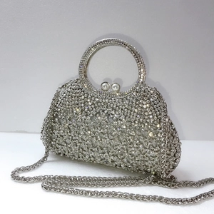 Détail du sac de soirée en strass avec fermoir perle et bandoulière chaîne argentée