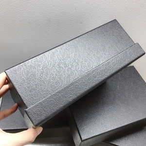 Detailed view of the black rectangular gift box with elegant paisley embossed texture