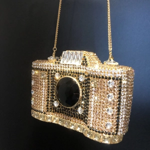 Macro shot of luxury camera-shaped evening clutch with gold and black crystal rhinestones