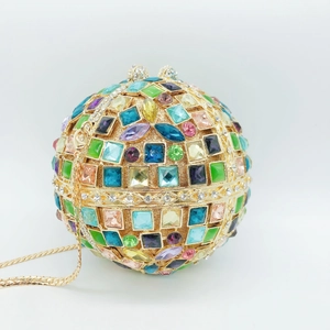 Detailed view of spherical evening bag with multicolored crystals and gold metal frame