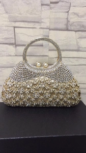 Détails d'un sac de soirée fleuri en strass avec dégradé et fermoir perle