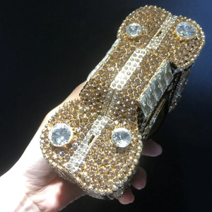 Luxury gold sports car shaped clutch bag encrusted with shimmering rhinestones