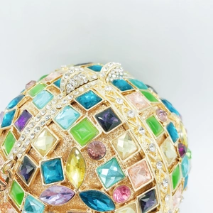 Spherical crystal ball clutch bag with vibrant multi-colored rhinestones and gold metal frame