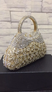 Détail de la pochette de soirée avec strass complexes et fermoir à perles chic
