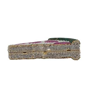 Macro detail of pizza slice clutch featuring colorful rhinestones and gold metal frame