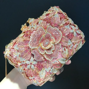 Detailansicht des rosa Kristall-Rosenmusters und Goldmetallrahmens der Abendhandtasche