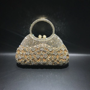 Détail du sac de soirée doré avec strass scintillants et poignée ornée de perles