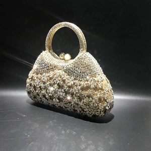 Détail de la pochette de soirée avec strass champagne, motif floral et fermoir en perles