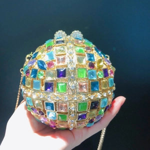 Detailed close-up of a colorful crystal ball evening bag with golden chain and clasp