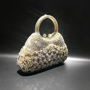 Gros plan d'une pochette de luxe avec strass et fermoir perle sur fond noir élégant