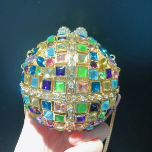 Macro detail of a spherical ball clutch with colorful crystals and gold metal frame