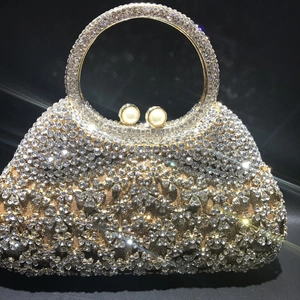 Détails d'une pochette dorée de luxe avec motifs floraux en strass et fermoir perle