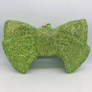 Close-up of emerald green bow evening clutch bag with luxury crystal rhinestones