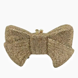 Close-up of golden bow-shaped evening bag with shimmering rhinestones and clasp detail