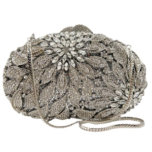 Detailed macro of oval clutch bag with floral leaf crystal pattern and silver chain strap