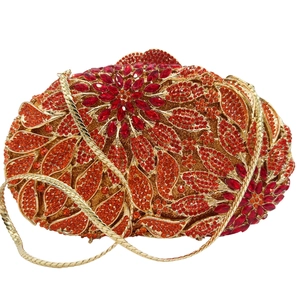 Detail of red and orange rhinestone leaf pattern on luxury metal evening clutch bag