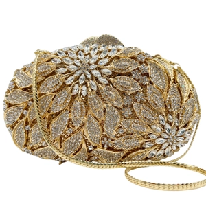 Detailed macro view of leaf and floral crystal patterns on a luxury gold clutch bag