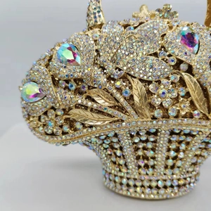Dettaglio ravvicinato della borsa da sera dorata con fiori in metallo e strass lucidi