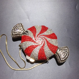Top view of a candy-shaped clutch bag with red and silver rhinestones and a gold chain