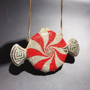 Macro detail of luxury candy-shaped clutch with red and silver rhinestones and gold chain