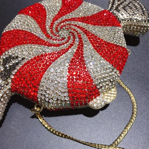Detail of candy-shaped evening clutch featuring red and white rhinestone spiral patterns