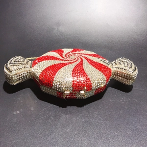 Macro view of candy-shaped evening clutch bag with red and clear crystal stripes